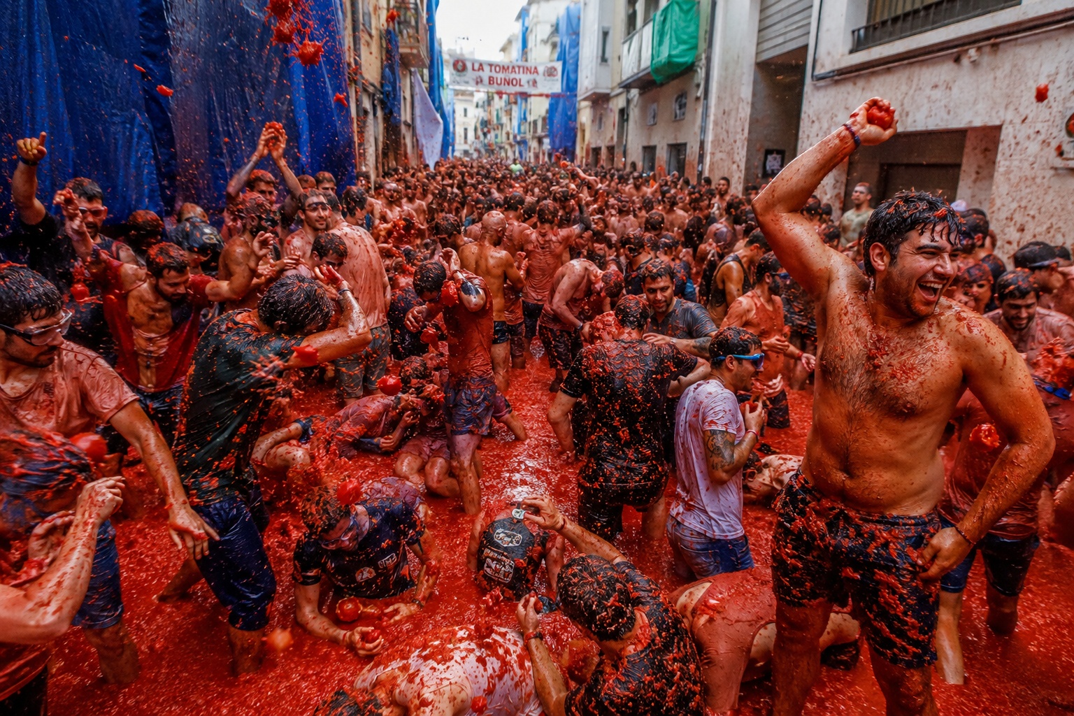 Crowds covered in tomatoes during the La Tomatina festival in Buñol, Spain