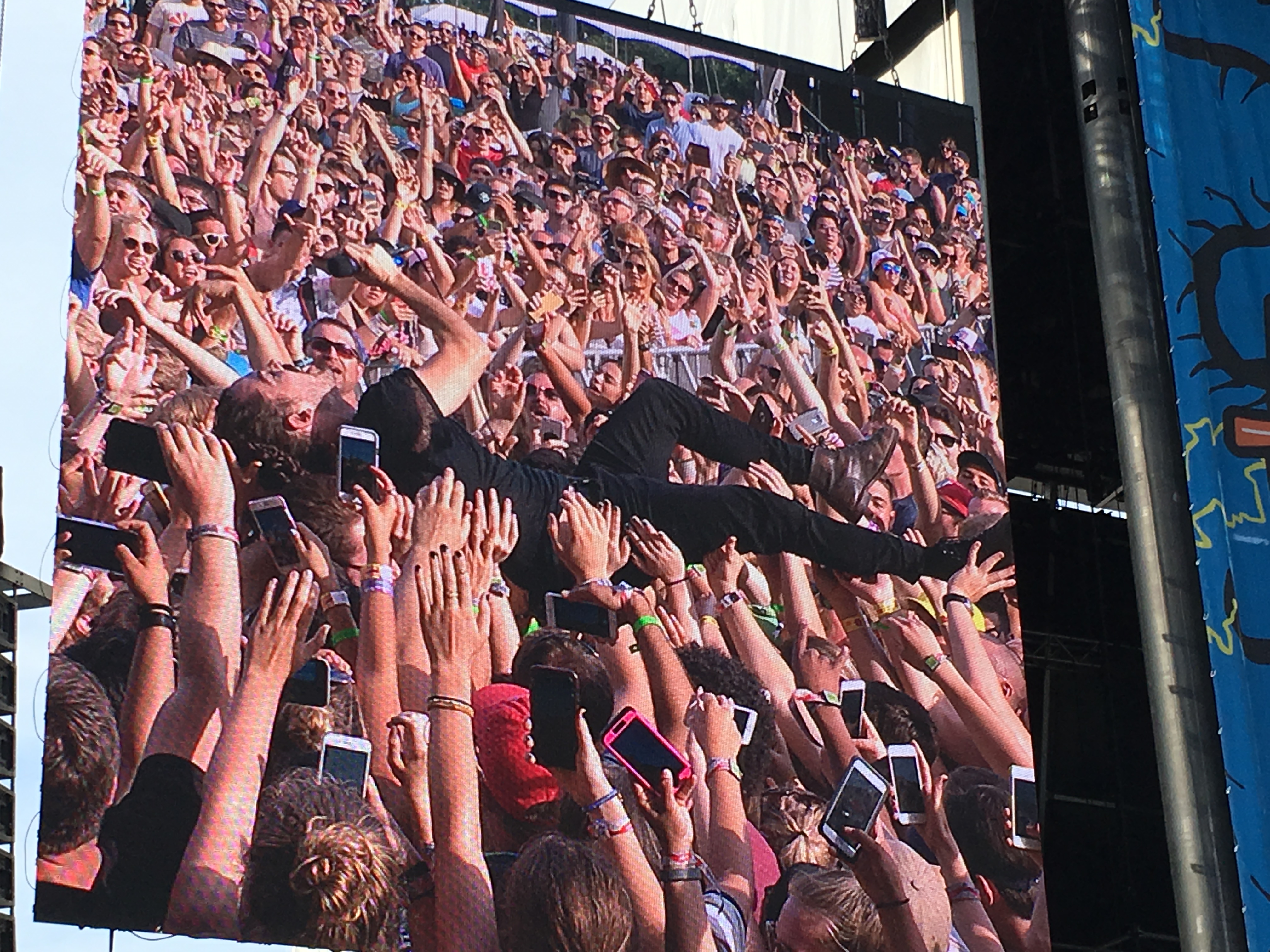 A band performing before a large festival crowd at Lollapalooza in Chicago