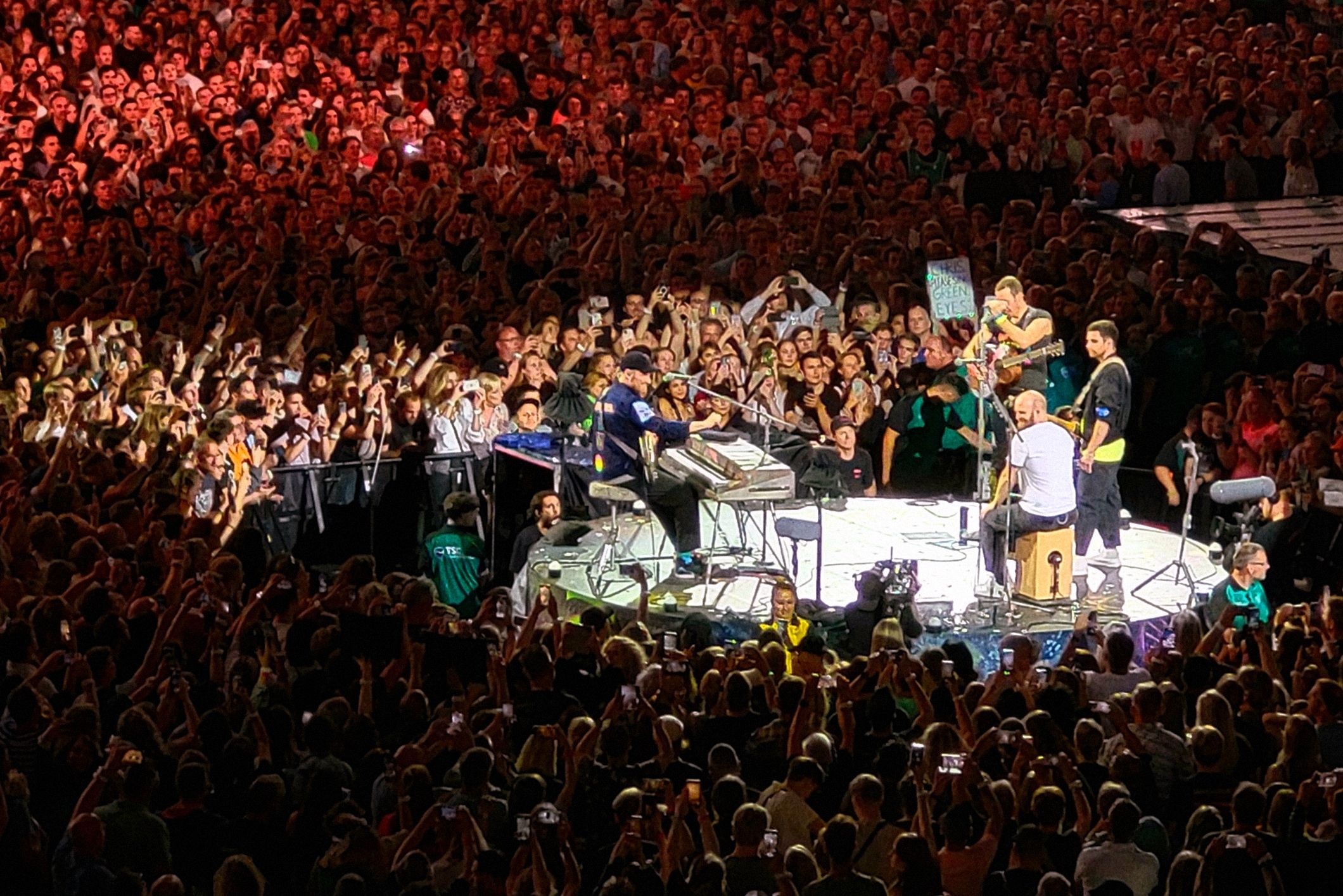 Coldplay performing on the Music of the Spheres stage before a wristband-lit crowd